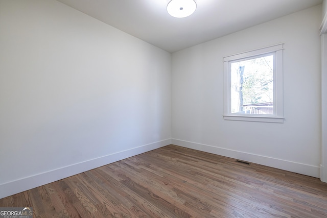 unfurnished room with hardwood / wood-style floors