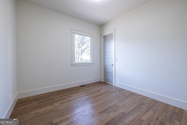 empty room with dark hardwood / wood-style floors