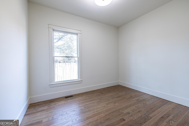 spare room featuring wood-type flooring