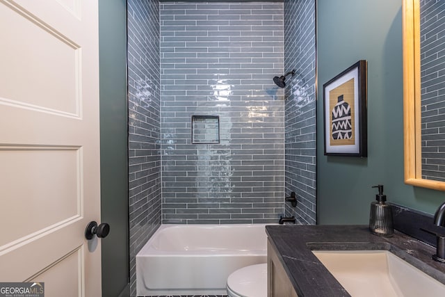 full bathroom with toilet, vanity, and tiled shower / bath