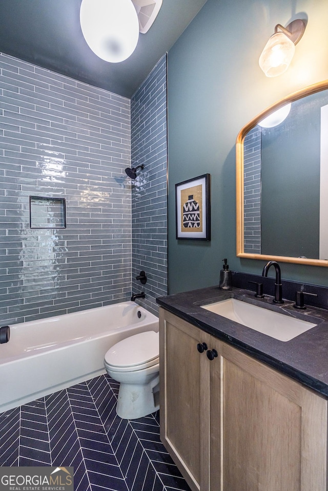 full bathroom featuring toilet, tiled shower / bath, tile patterned floors, and vanity