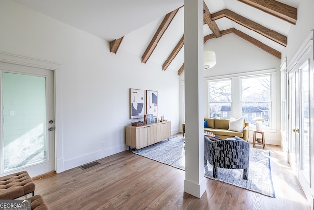 living area featuring high vaulted ceiling, wood-type flooring, and beamed ceiling