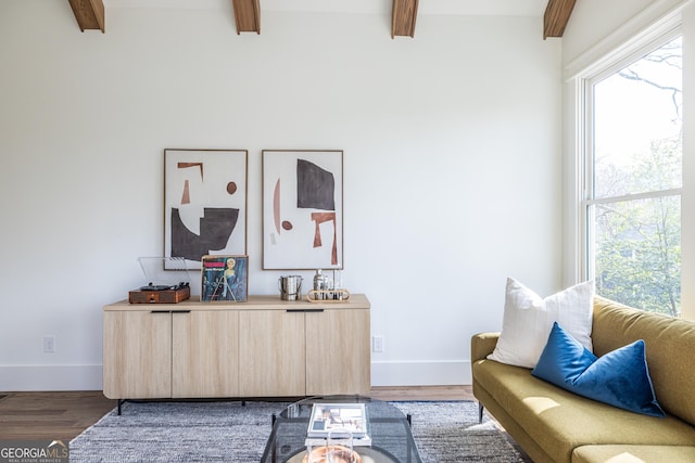 living room with dark hardwood / wood-style flooring and beam ceiling