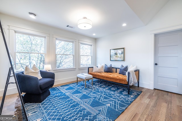 sitting room with wood-type flooring and vaulted ceiling