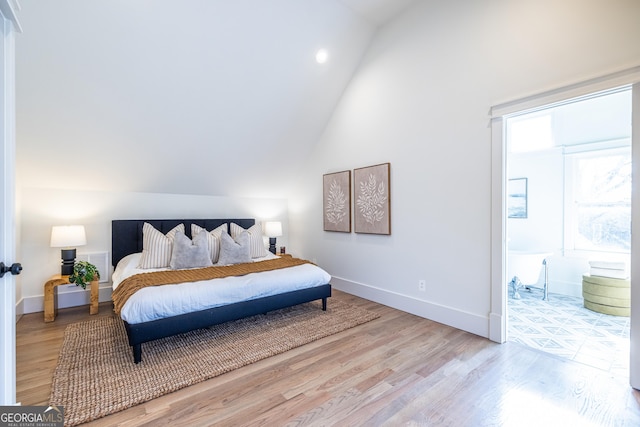 bedroom with lofted ceiling and light wood-type flooring