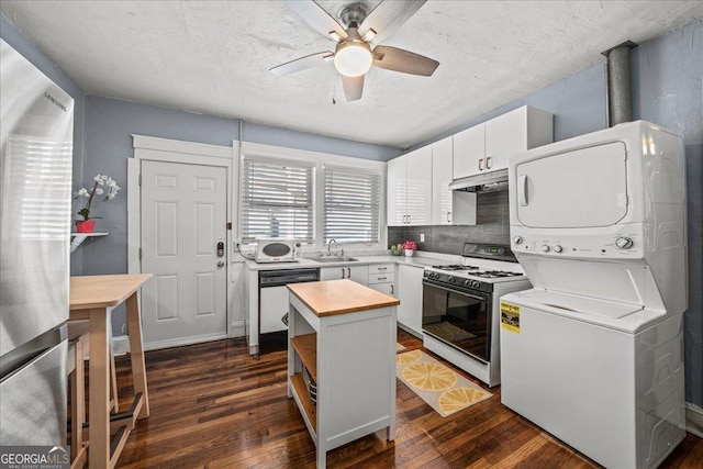 kitchen with dishwashing machine, white cabinets, a center island, stacked washer / drying machine, and white range with gas stovetop