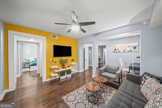 living room with ceiling fan and dark wood-type flooring