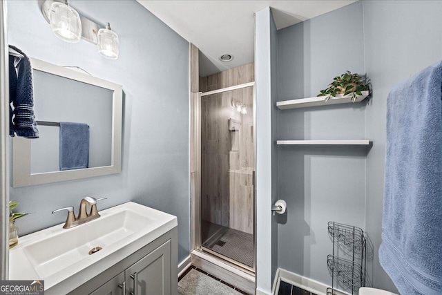 bathroom with a shower with shower door and vanity