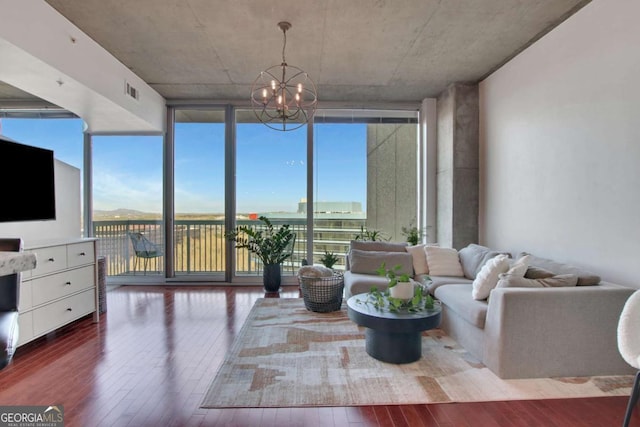 living room featuring an inviting chandelier, expansive windows, and wood-type flooring