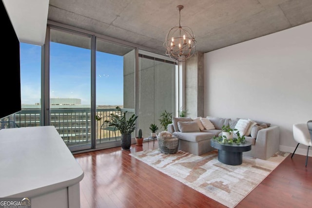 living room featuring wood-type flooring, an inviting chandelier, and expansive windows