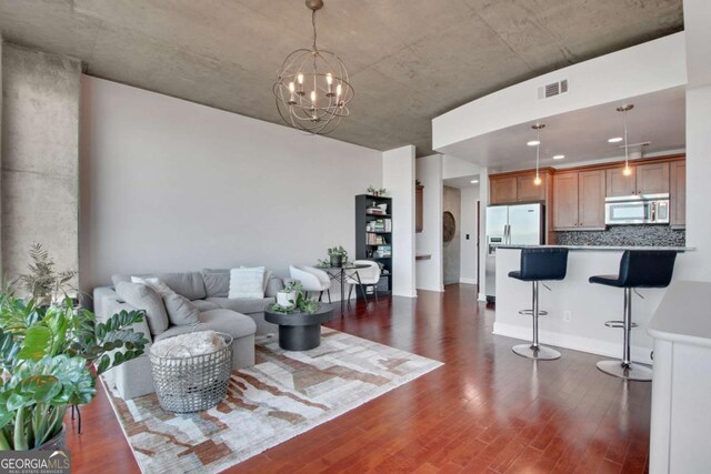 living room featuring an inviting chandelier and dark hardwood / wood-style floors