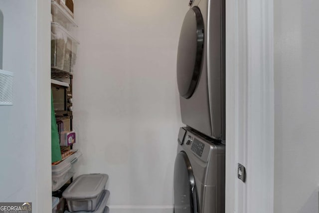 clothes washing area featuring stacked washer and clothes dryer