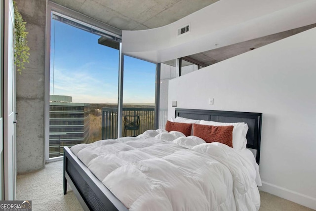 bedroom featuring light colored carpet and expansive windows