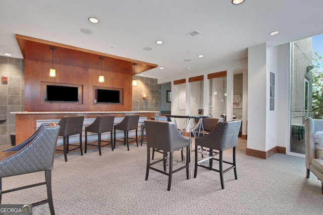 carpeted dining space featuring tile walls