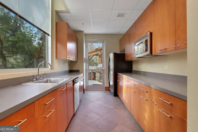 kitchen featuring stainless steel appliances, a drop ceiling, and sink