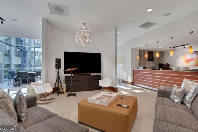 living room featuring light tile patterned flooring, a notable chandelier, and expansive windows