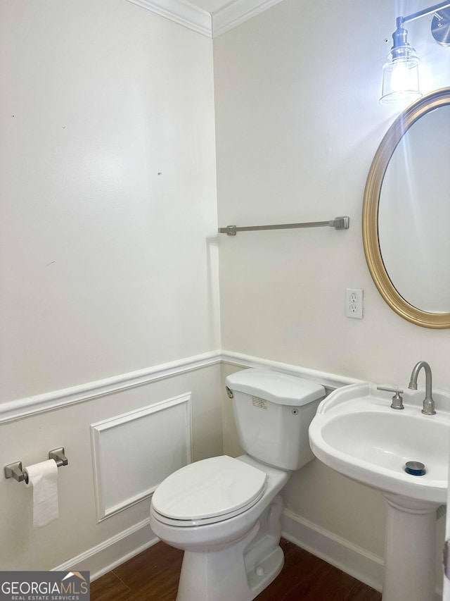 bathroom featuring ornamental molding, toilet, and wood-type flooring