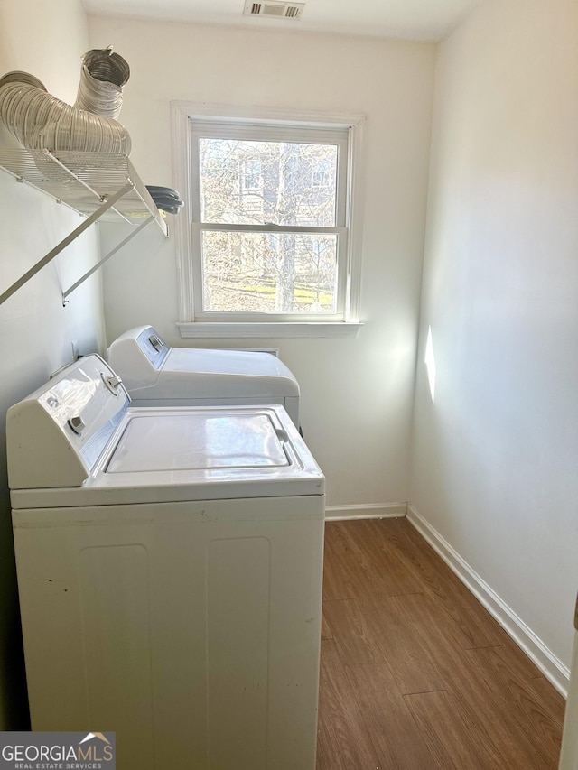 laundry room with hardwood / wood-style flooring and independent washer and dryer