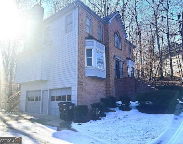 view of snow covered exterior featuring a garage