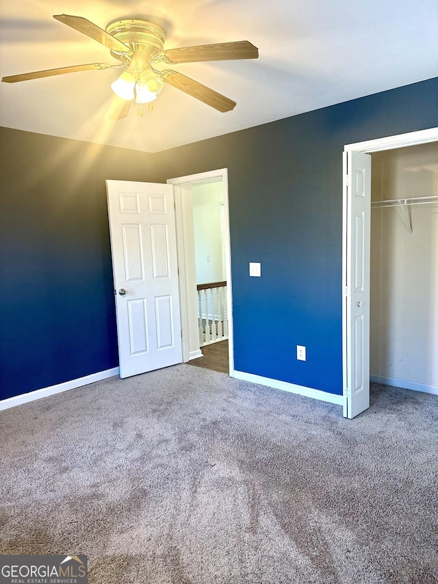 unfurnished bedroom featuring ceiling fan, a closet, and carpet