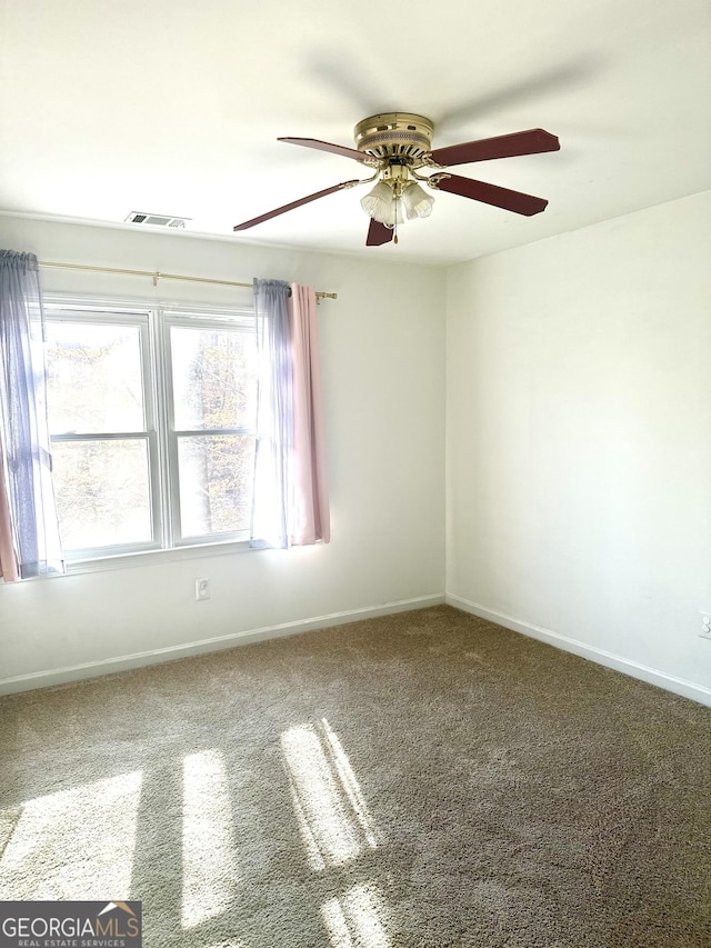 spare room with ceiling fan and carpet