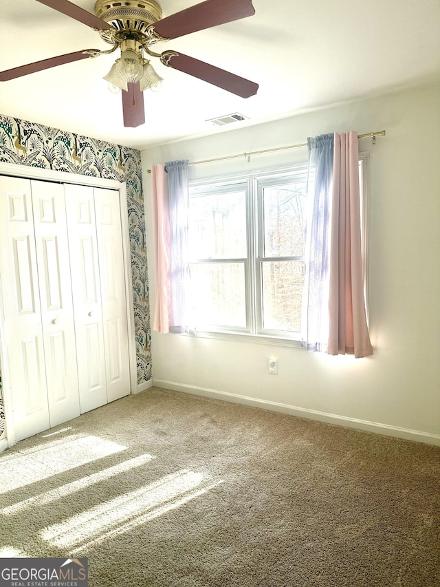 unfurnished bedroom featuring a closet, ceiling fan, and carpet