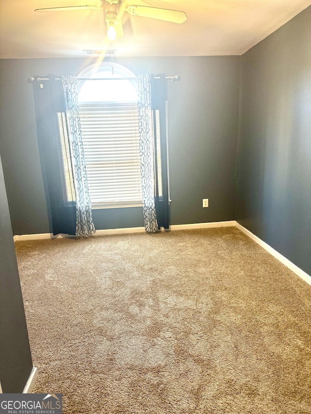 carpeted empty room featuring ceiling fan