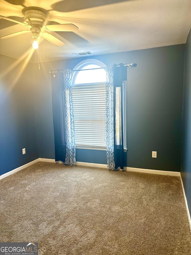 carpeted spare room featuring ceiling fan