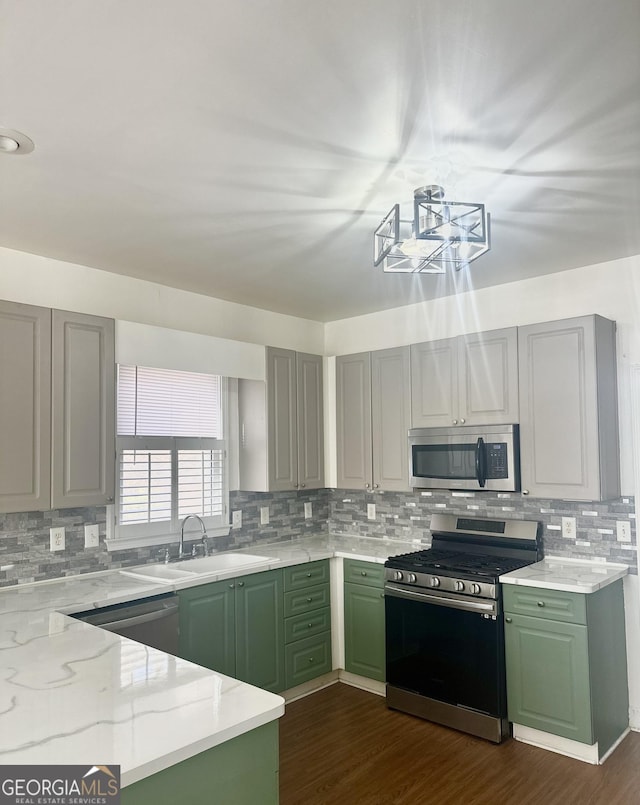 kitchen featuring light stone counters, sink, appliances with stainless steel finishes, and green cabinets