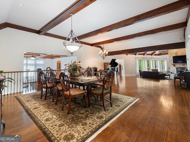 dining space featuring a fireplace, dark hardwood / wood-style flooring, beam ceiling, and ceiling fan with notable chandelier