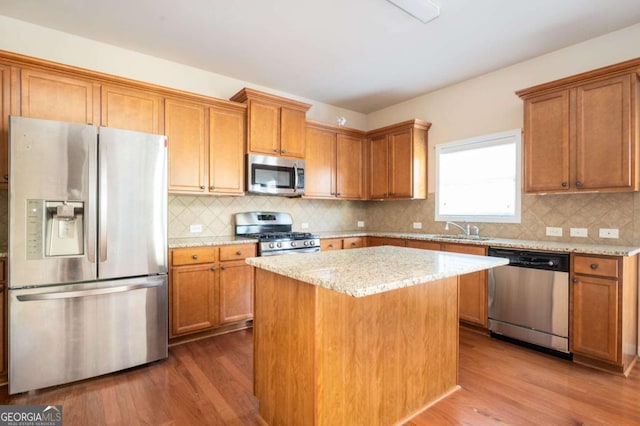 kitchen featuring sink, stainless steel appliances, dark wood-type flooring, and a center island