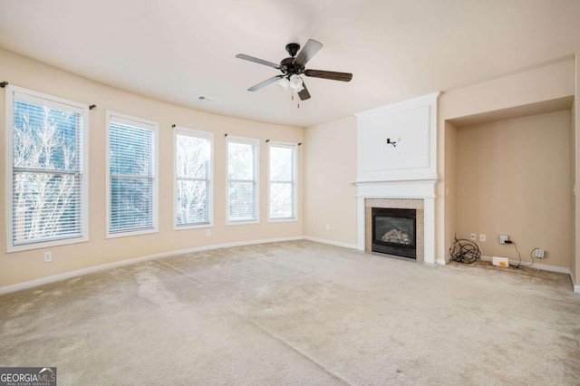 unfurnished living room featuring ceiling fan, light carpet, and a fireplace