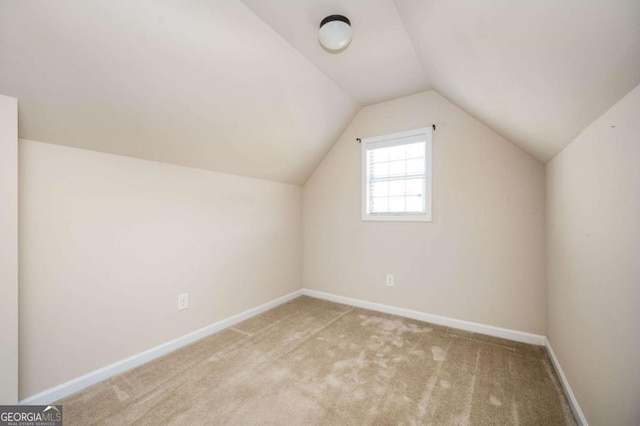 bonus room with light carpet and lofted ceiling