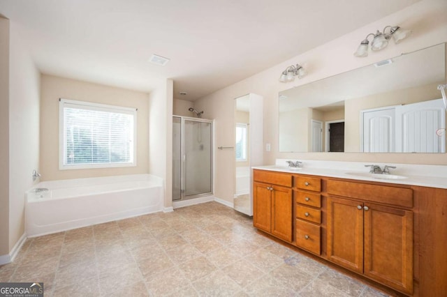 bathroom featuring vanity, a healthy amount of sunlight, and separate shower and tub