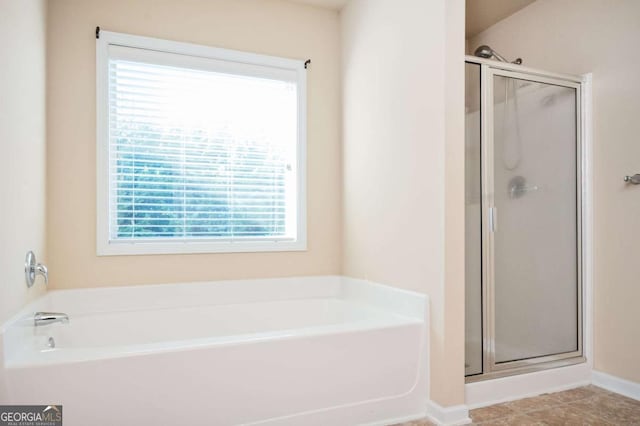 bathroom featuring a wealth of natural light and independent shower and bath