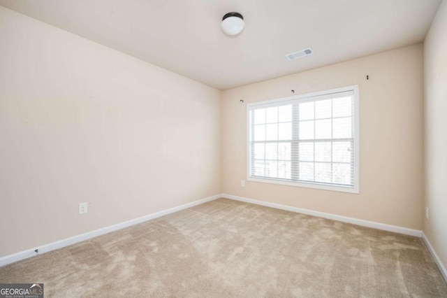 spare room featuring light colored carpet