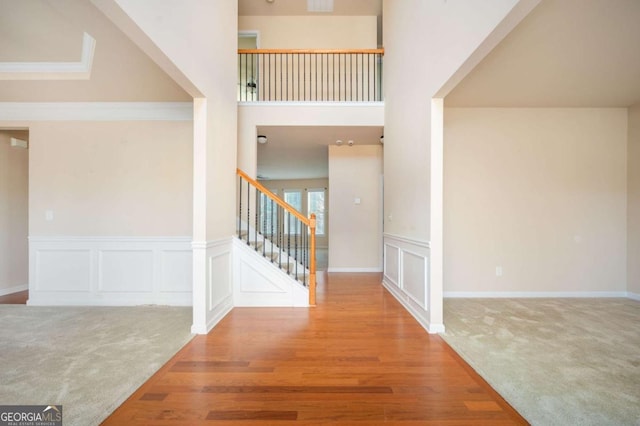 carpeted foyer featuring ornamental molding