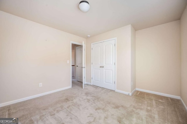 unfurnished bedroom featuring a closet and light carpet