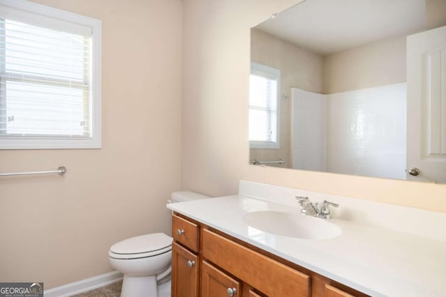 bathroom with toilet, vanity, and walk in shower