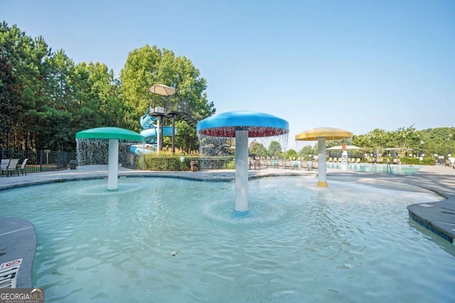 view of swimming pool with pool water feature and a water slide