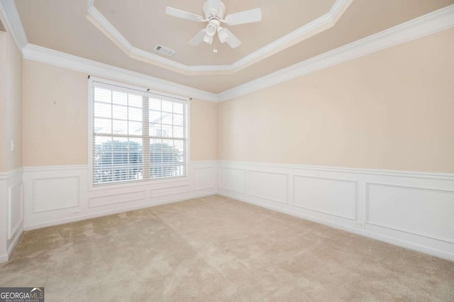 unfurnished room featuring ornamental molding, light colored carpet, a raised ceiling, and ceiling fan