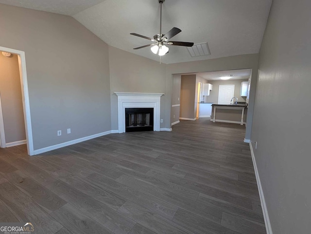 unfurnished living room with lofted ceiling, sink, ceiling fan, and dark wood-type flooring