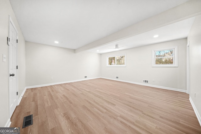 basement with ceiling fan and light hardwood / wood-style floors