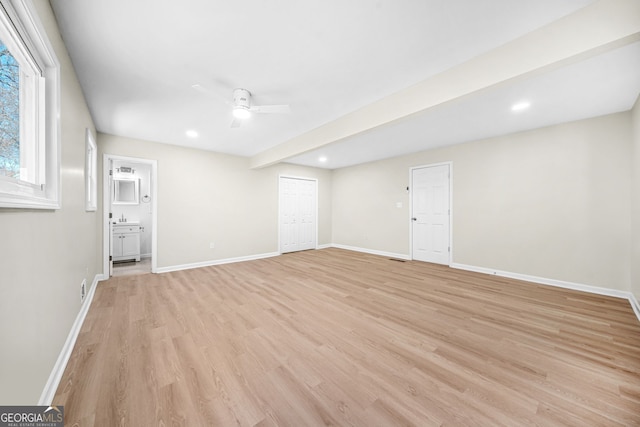 empty room with ceiling fan and light hardwood / wood-style flooring