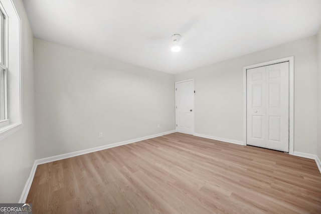 unfurnished bedroom featuring a closet and light hardwood / wood-style floors