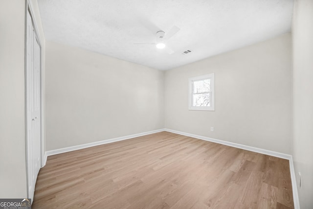 unfurnished room with light hardwood / wood-style floors, ceiling fan, and a textured ceiling