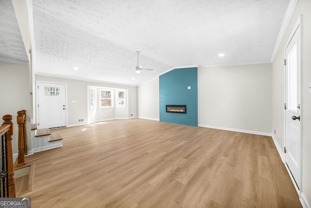 unfurnished living room featuring a fireplace, ornamental molding, a textured ceiling, and light hardwood / wood-style flooring