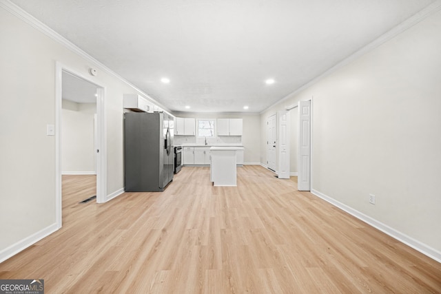 kitchen featuring appliances with stainless steel finishes, light hardwood / wood-style floors, white cabinets, and ornamental molding