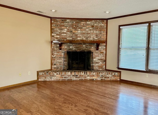 unfurnished living room with a textured ceiling, ornamental molding, and wood-type flooring