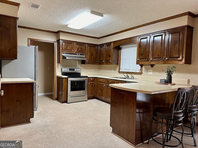 kitchen with kitchen peninsula, a textured ceiling, stainless steel appliances, a breakfast bar, and sink